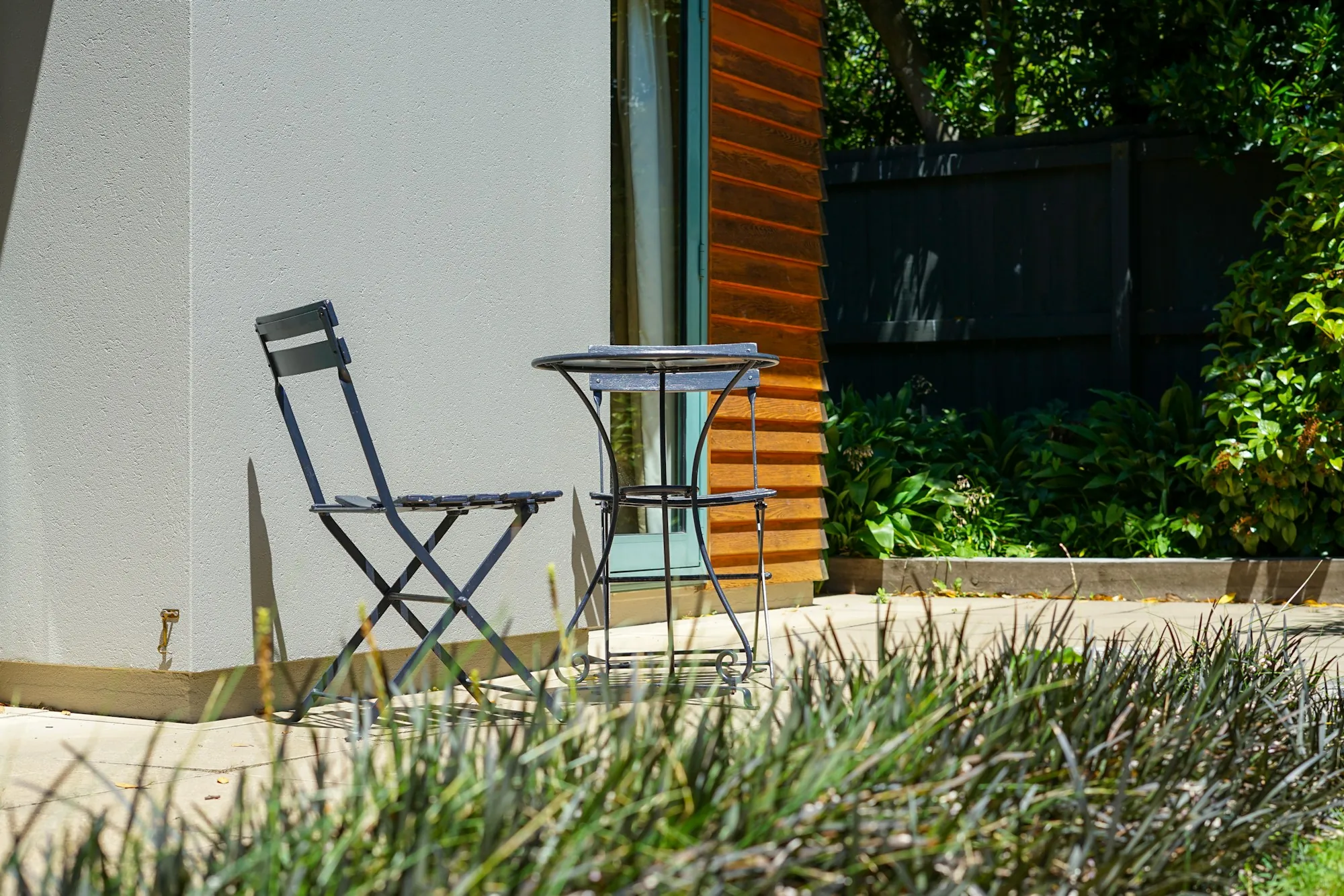 Bistro table and folding chairs on a small concrete patio